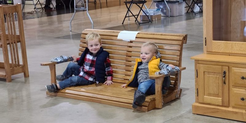 2 little boys sitting on a swing